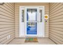 Close-up of the front door with decorative glass, welcoming mat, and 'welcome' sign at 224 Cupola Dr., Longs, SC 29568