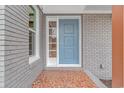A close-up of the light blue front door and brick facade with a mosaic tile entryway at 2360 Highway 701 North, Loris, SC 29569