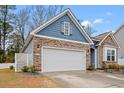 Spacious two car garage with stone and siding exterior is perfect for storing vehicles and more at 414 Antietam Place, Little River, SC 29566
