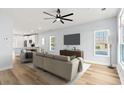 Contemporary living room featuring hardwood floors, large windows, and ceiling fan at 6606 Wildwood Trail # E, Myrtle Beach, SC 29572
