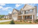 Two-story home with tan siding, dark shutters, stone accents, attached two-car garage, and a well-manicured lawn at 7006 Shooting Star Way, Myrtle Beach, SC 29579