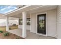 A covered front porch with white columns leads to a black front door with glass panel at 7011 Shooting Star Way, Myrtle Beach, SC 29579