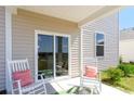 Relaxing back patio with rocking chairs, green mat and outdoor view at 815 Green Garden Way, Myrtle Beach, SC 29579