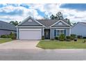 Inviting single-story home boasts a manicured lawn and an attached two-car garage at 1182 Palm Crossing Dr., Little River, SC 29566