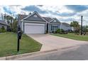 Inviting home exterior with a long driveway, lush green lawn, and mailbox at 1182 Palm Crossing Dr., Little River, SC 29566