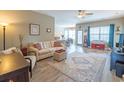 Open-concept living room with a comfortable sofa, ceiling fan, and lots of natural light at 1182 Palm Crossing Dr., Little River, SC 29566