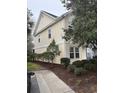 A yellow townhome featuring tidy landscaping and a sidewalk at 1742 Low Country Pl. # A, Myrtle Beach, SC 29577