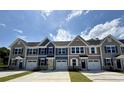 Modern townhomes featuring coordinated exteriors, attached garages, and well-manicured lawns at 2063 Nw Parow Ln Nw # E, Calabash, NC 28467