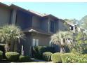 Exterior of condo featuring mature landscaping, including palms, shrubs and flowering plants at 207 Indian Wells Ct. # 207, Murrells Inlet, SC 29576