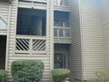 Exterior view of the condominium featuring wood siding, small balcony and mature landscaping at 207 Indian Wells Ct. # 207, Murrells Inlet, SC 29576