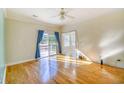 Bright living room with wood floors, ceiling fan, sliding glass doors, and an additional sunroom adjacent to the room at 221 Hagley Dr., Pawleys Island, SC 29585