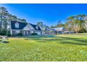 Expansive green lawn showcases this home with a brick exterior, dormer windows and separate garage on the property at 221 Hagley Dr., Pawleys Island, SC 29585