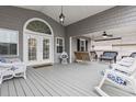 Cozy porch featuring an arched door, a swing, and comfortable wicker chairs at 300 Oak Lake Circle, North Myrtle Beach, SC 29582