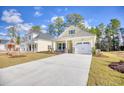 Attractive single-Gathering home with bright yellow siding, stone accents, and a pristine concrete driveway at 3127 Tiger Tail Rd., Conway, SC 29526