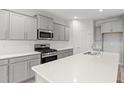 Modern kitchen with stainless steel appliances, white countertops and grey cabinets at 3332 Little Bay Dr., Conway, SC 29526