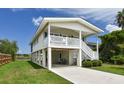 Exterior featuring elevated design with covered parking, lush landscaping, and waterfront views at 342 Dogwood Dr. S, Murrells Inlet, SC 29576