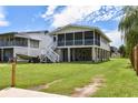 Rear view of house featuring screened in porch, elevated design and lush yard at 342 Dogwood Dr. S, Murrells Inlet, SC 29576