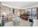 Bright living room featuring a patterned sofa, leather recliner, and balcony access at 400 20Th Ave. N # 101, Myrtle Beach, SC 29577