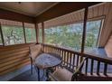 Relaxing screened-in porch offers views of the community landscaping with table and chairs at 410 Melrose Pl. # 304, Myrtle Beach, SC 29572