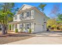 Charming two-story home with an attached two-car garage, complimented by dark shutters and lush landscaping at 425 Retriever Ct., Murrells Inlet, SC 29576