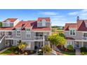 Well-manicured condo building with red roof, gray wood shingles, and a view of landscaped grounds at 4396 Baldwin Ave. # 19, Little River, SC 29566