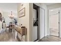 Hallway featuring a washer/dryer closet, access to bathroom, and views of dining area with hardwood floors and chandelier at 4502 Little River Inn Ln. # 2507, Little River, SC 29566