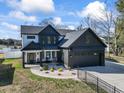 Beautiful two-story farmhouse-style home with modern black and white accents, featuring a well-kept lawn and an attached garage at 4860 Mill Pond Rd., Myrtle Beach, SC 29588