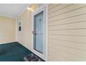 Front door entrance featuring yellow siding and a storm door with a screen at 4872 Dahlia Ct. # 202, Myrtle Beach, SC 29577