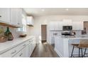 Bright kitchen with white cabinetry, quartz countertops, a mosaic backsplash and wood-look floors at 538 Haven View Way, Murrells Inlet, SC 29576