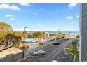 View of a parking lot with designated handicapped spots with beach, palm trees and ocean in the background at 5905 S Kings Hwy. # 327 A, Myrtle Beach, SC 29575