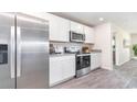 Bright kitchen with stainless steel appliances, white cabinets, granite countertops, and wood-look flooring at 836 Buttonwood Dr., Conway, SC 29527