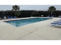 Community swimming pool surrounded by lounge chairs and greenery at 113 Butkus Dr. # 3, Myrtle Beach, SC 29588