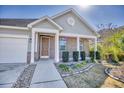 Inviting front porch with brick accents, columns, and a meticulously landscaped garden at 1537 Beaumont Way, Myrtle Beach, SC 29577