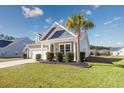 Charming single-story home featuring a well-manicured lawn and a welcoming front porch with inviting chairs at 2051 Lindrick Ct., Calabash, NC 28467