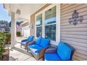 Inviting front porch featuring comfortable seating with wicker chairs and blue cushions at 2051 Lindrick Ct., Calabash, NC 28467