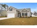 Charming single-story home with a two-car garage and neutral colored vinyl siding at 349 Lakota Loop, Longs, SC 29568