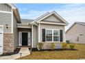 Front entrance of the house features brick accents and manicured landscaping at 349 Lakota Loop, Longs, SC 29568