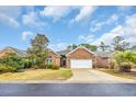 Inviting brick home with a well-kept lawn and a spacious driveway leading to the garage at 3791 Cagney Ln., Myrtle Beach, SC 29577