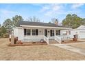 Charming home featuring a cozy front porch with classic white railings and brick accents at 410 Martin St., Mullins, SC 29574