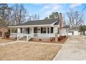 Charming home featuring a cozy front porch with classic white railings and brick accents at 410 Martin St., Mullins, SC 29574