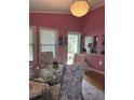 Dining room featuring pink walls, a glass table, and views of the outdoor garden at 4115 Little River Rd., Myrtle Beach, SC 29577