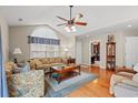 Sunlit living room with hardwood floors, a ceiling fan, and a view into adjacent room at 4309 River Gate Ln., Little River, SC 29566