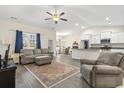 Open concept living room and kitchen area with hardwood floors, natural lighting, and a ceiling fan at 453 Rycola Circle, Surfside Beach, SC 29575