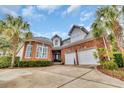 Imposing brick home showcasing a two-car garage and well-maintained landscaping at 602 Sea Vista Ln., North Myrtle Beach, SC 29582