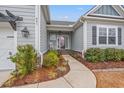 Inviting front entrance featuring a cozy rocking chair and thoughtfully designed landscaping with pathway lighting at 641 Indigo Bay Circle, Myrtle Beach, SC 29579