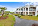 Scenic view of the townhome's exterior, featuring a tranquil waterfront view, a walking path and lush landscaping at 8035 Arcady St. # B, Myrtle Beach, SC 29572