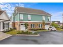 Townhome featuring an attached garage, lush landscaping, and charming shuttered windows at 8035 Arcady St. # B, Myrtle Beach, SC 29572