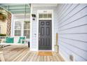 Charming home exterior with a black front door and inviting porch swing at 843 Howard Ave., Myrtle Beach, SC 29577