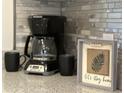 Close-up of decorative countertop decor including a coffee maker, mugs, and framed wall art at 901 West Port Dr. # 1807, North Myrtle Beach, SC 29582