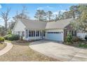 Charming single-story home with a covered porch, two-car garage, and a well-maintained front yard at 10-1 Rattan Circle # 1, Pawleys Island, SC 29585